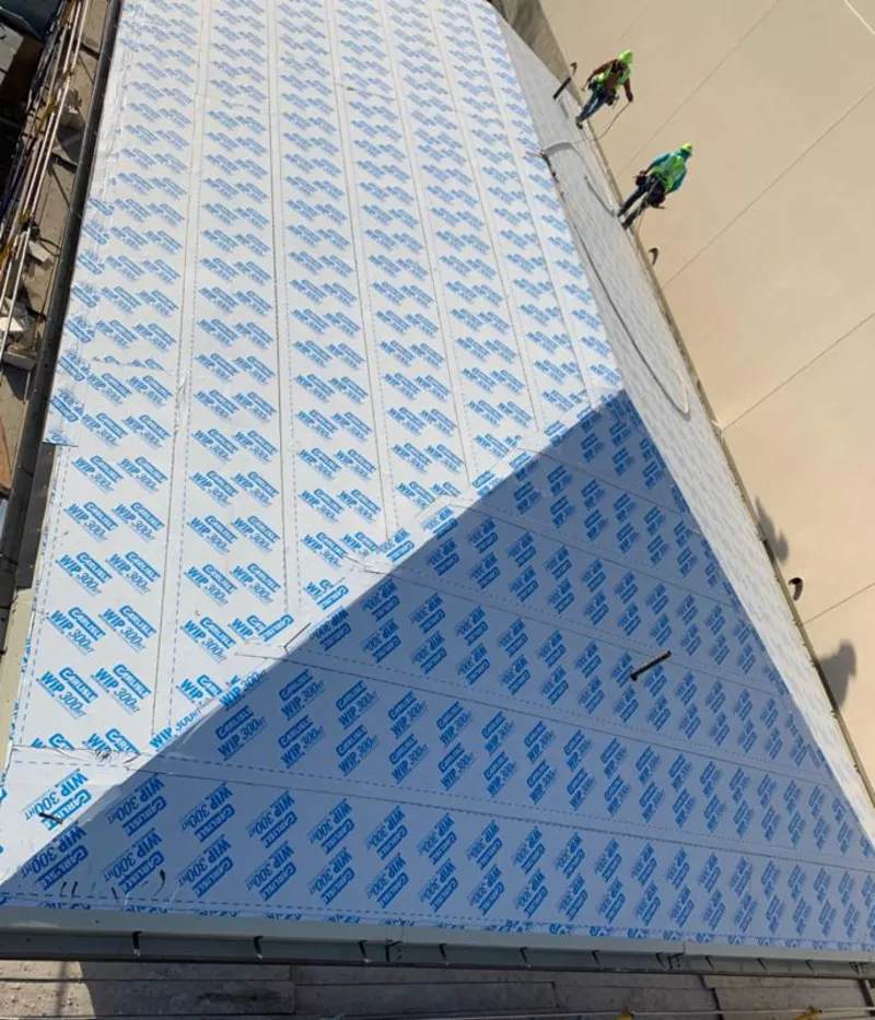 Professional roofers installing underlayment on a metal roof in PiÃ±on Hills